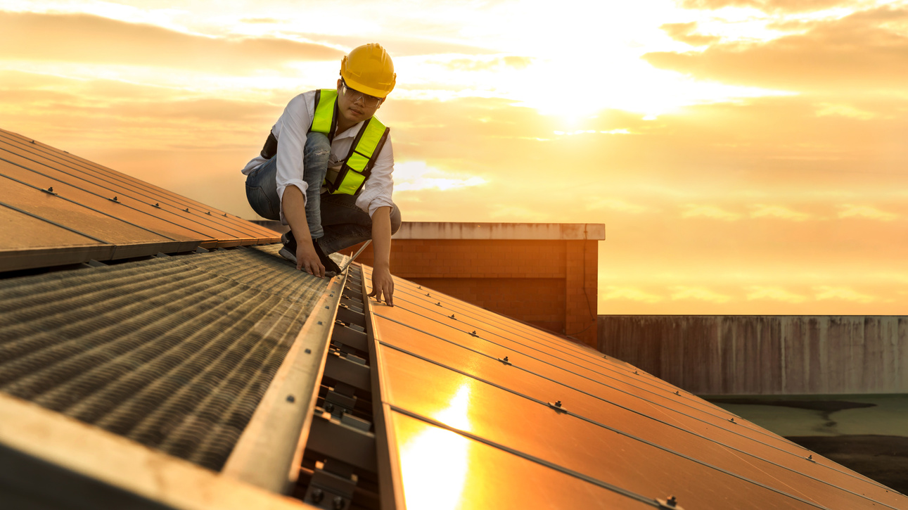 Engineer working setup Solar panel at the roof top. Engineer or worker work on solar panels or solar cells on the roof of business building